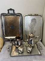 Full view photo of silver tea set with three trays showing size and arrangement