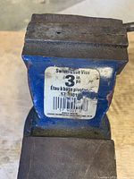 Close-up of the vise jaw area showing the label identifying as Swivel Base Vise 3 inch, with visible wear and paint chipping.
