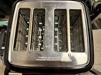 Top view showing four bread slots with metal grill and warning text