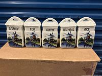 Front view of 5 ceramic canisters labeled Barley, Tea, Coffee, Oatmeal, Rice with windmill scenery