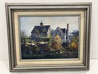 Framed front view of the oil panel landscape painting showing two houses and quarry foliage.