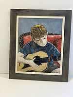 Framed oil painting showing a young person playing a guitar, signed NH, with original frame in good condition.