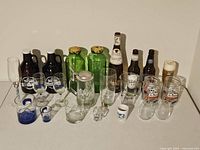 View of all barware and glassware items on display including growlers, shot glasses, wine glasses, mason jars, and empty beer bottles