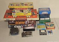 Multiple board and card games stacked and arranged, showing titles and packaging states.