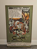 Front view of the wood-framed Squirm horror movie poster with visible wear on frame edges and surface.
