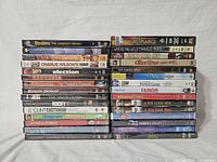 Photo showing the full lot of DVDs stacked in two piles with titles visible