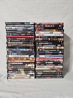 Stack of 56 used DVD cases, titles visible include Fight Club, Gladiator, Bourne series, Taken, Unknown and more.