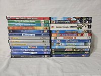 Photo showing stacked DVDs of various animated and children's movies including Disney classics, Toy Story series, Shaun the Sheep, and others.