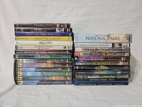 Photo of all DVDs in the lot arranged in stacks on a white sheet background showing titles and packaging