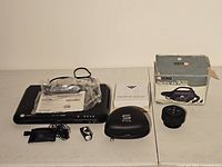 Complete lot displayed on white surface including Sabre HDMI DVD player, remote, booklet, wired earbuds, case for 3D glasses, wireless speaker, electric air pump box.