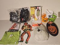 Full view of all items laid out on a flat surface showing costumes, buckets, towels, cardboard figure, and wig