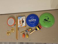 Full top-down view of the assorted kid's musical instruments and two frisbees.