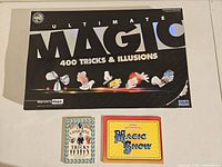 Closed cover of Ultimate Magic 400 Tricks & Illusions kit with two magic books in front.
