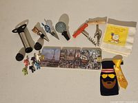 Photo showing entire assortment of wine-related accessories including vacuum pump, bottle stoppers, corkscrews, drink markers, coasters, bottle collar and cozy.