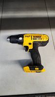 Side view of the DeWalt 20V Max drill showing yellow and black body with some paint wear.