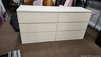 Front view of the six-drawer white dresser showing the clean drawer fronts and overall rectangular shape.