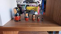 Full set of five Star Trek themed wooden nesting dolls arranged largest to smallest on dark wood surface