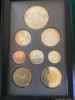 Proof set coins arranged in black display case showing all eight coins and their designs clearly visible