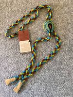 Full view of braided beaded necklace laid out, showing adjustable length and original tag attached.