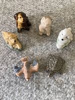 Front view of six animal ceramic figurines on carpet.
