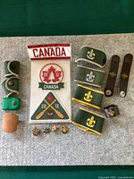 Full lot view showing all scouting items laid out on green surface including patches, pins, wristbands, and leather staff holder.
