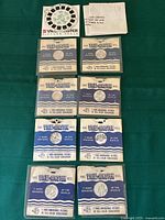 Photo of eight View-Master reels laid out showing packaging and labels highlighting the 7 Wonders of the World series, Desert Cactus in Bloom, and The Tower of London.