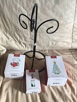 Full lot showing black metal stand and three boxed Hallmark ornaments
