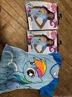 Two sealed Rainbow Dash shirts and one loose shirt displayed