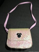 Front view of glitter purse with Mickey emblem and strap