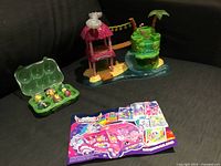 Overall shot showing playset, egg carton with figures, and collector sheet