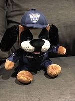 Front view of plush paramedic dog showing uniform, cap and embroidered details
