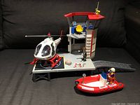 Overall view showing helicopter, tower, boat and figures