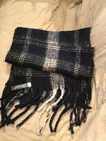 Full view of folded plaid scarf showing pattern and fringe