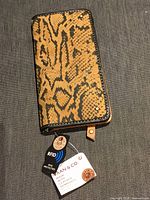 Front exterior showing snakeskin print and hang tags