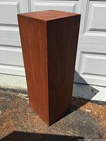 Full front view of wooden pedestal showing brown finish and overall condition