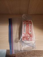 Plastic resealable bag open with visible dollar 1 Canadian Tire money bills stacked inside.