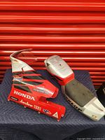 Front and side views of mini bike body parts including red front fairing and black seat