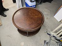 Top view of round wooden coffee table showing circular top with marks and scratches.
