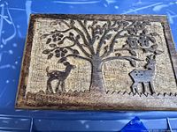 Top view of the wooden box lid with carved deer and tree design.
