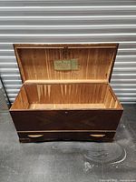 Photo of the open wooden chest showing cedar-lined interior and lock mechanism.