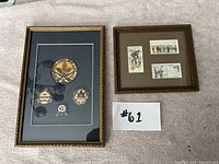 Two framed curling memorabilia pieces together on floor, one with pins and patch, one with art prints
