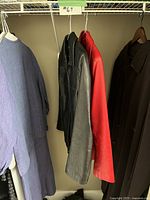 Closet view showing black, red, and brown jackets with a label #67