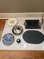 Full view of six items laid out showing four plates, two serving items and a small round trinket box.
