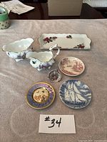 Full lot overview showcasing all seven pieces including two gravy boats, rectangular tray, and five decorative plates with various motifs and colors.