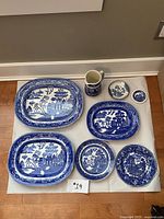 Full view of the 8-piece set of Wedgwood blue and white servingware and platters arranged on a white surface.