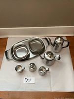 Full set including teapot, sugar bowl, creamer, salt and pepper shakers, two square serving dishes, and rectangular tray with black handles.