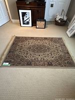 Full view of the rectangular oriental style area rug showing central medallion and floral motifs with fringe edges.