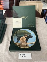 Collector's plate in open box with certificate of authenticity displayed, showing signature and title.
