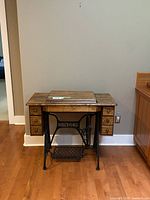 Front view of oak Singer sewing table with drop leaves folded down