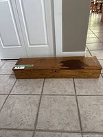 Side view showing the length, wood grain, and discoloration on lid